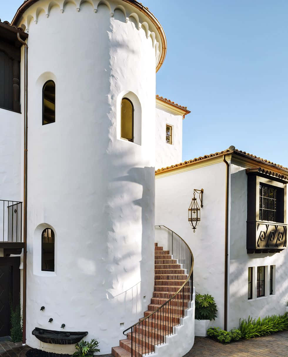 En hvid hus med en spiraltrappe og en altan