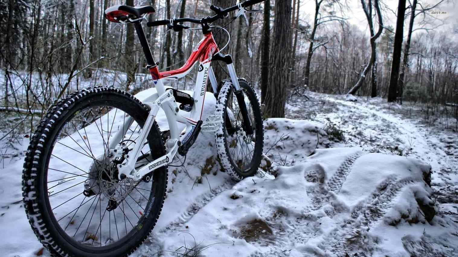 En mountainbike er parkeret i sneen Wallpaper