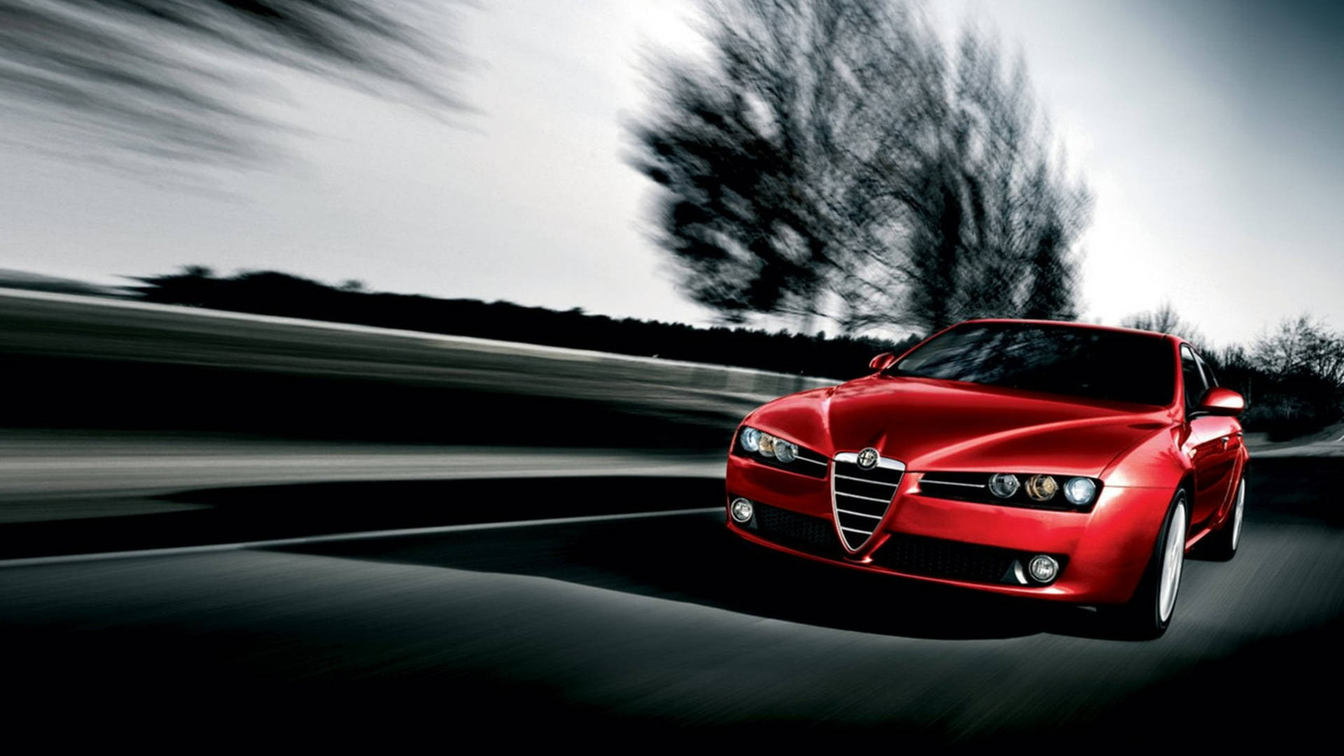 Speeding red Alfa Romeo 159 compact executive car wallpaper.