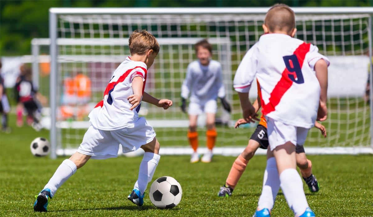 Spirited Young Players At A Kid's Soccer Match Wallpaper