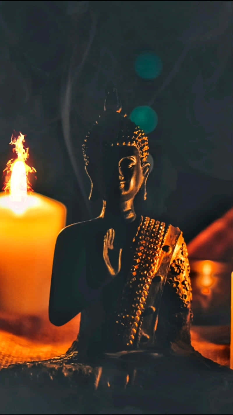 A Buddha Statue With Candles And Candles Wallpaper