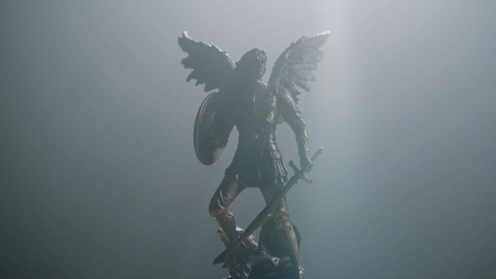 A Statue Of An Angel With A Shield In The Light Wallpaper
