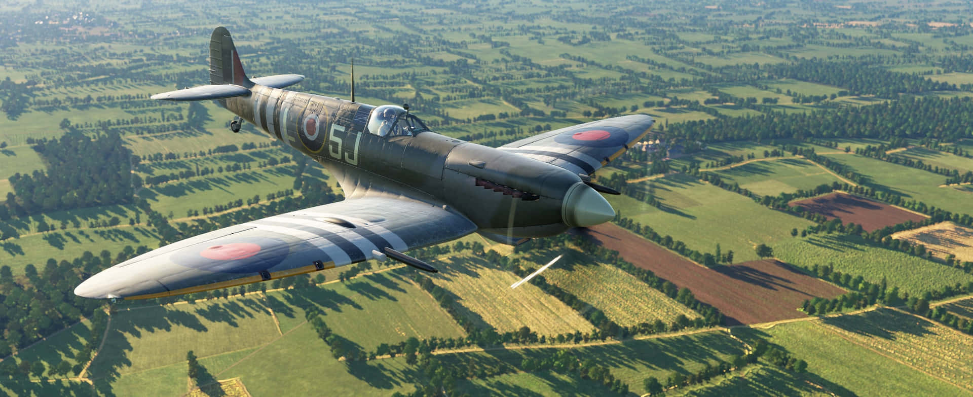 A Vintage Fighter Plane Flying Over A Field Wallpaper