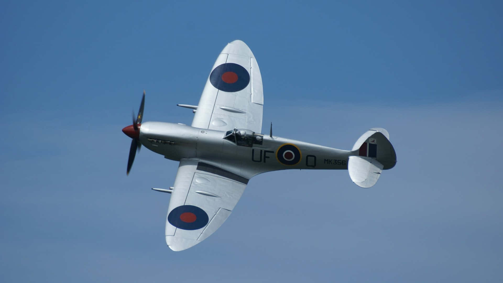 Smukke britiske Spitfire krigsflyet sejler i himlen Wallpaper