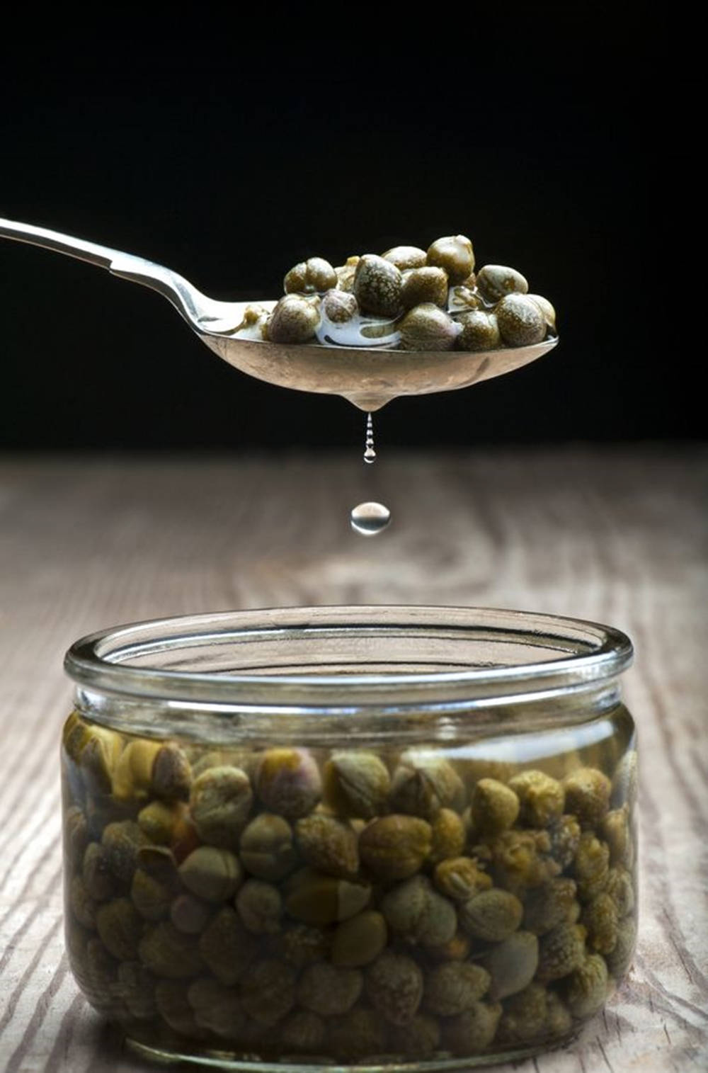 Spoonful Of Capers In A Jar Of Olive Oil Wallpaper