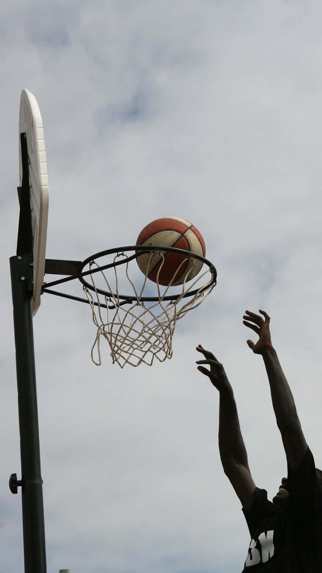Sfondocon Un'immagine Di Un Atleta Sportivo Che Tira A Canestro Durante Una Partita Di Basket.