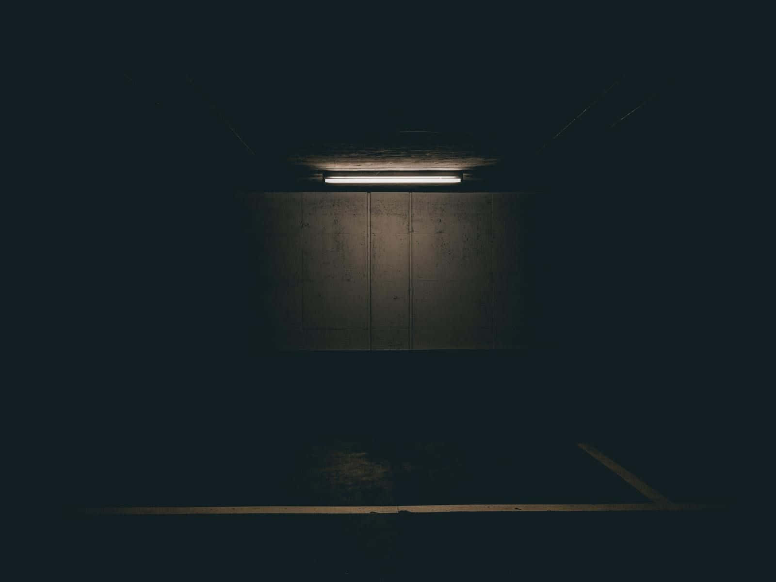 Ungarage Di Parcheggio Buio Con Una Luce Che Brilla Su Di Esso