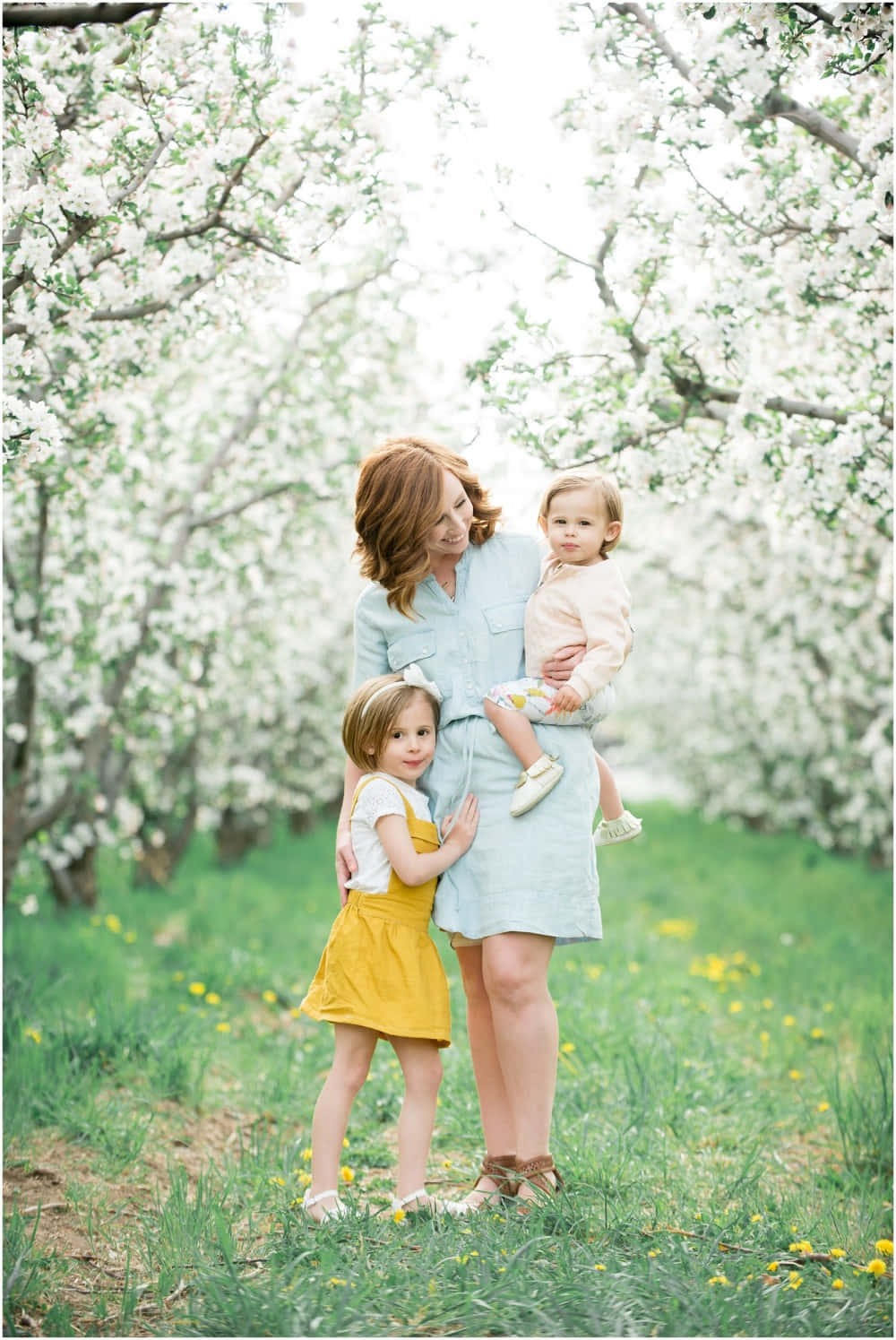 A Woman And Her Two Children In An Orchard