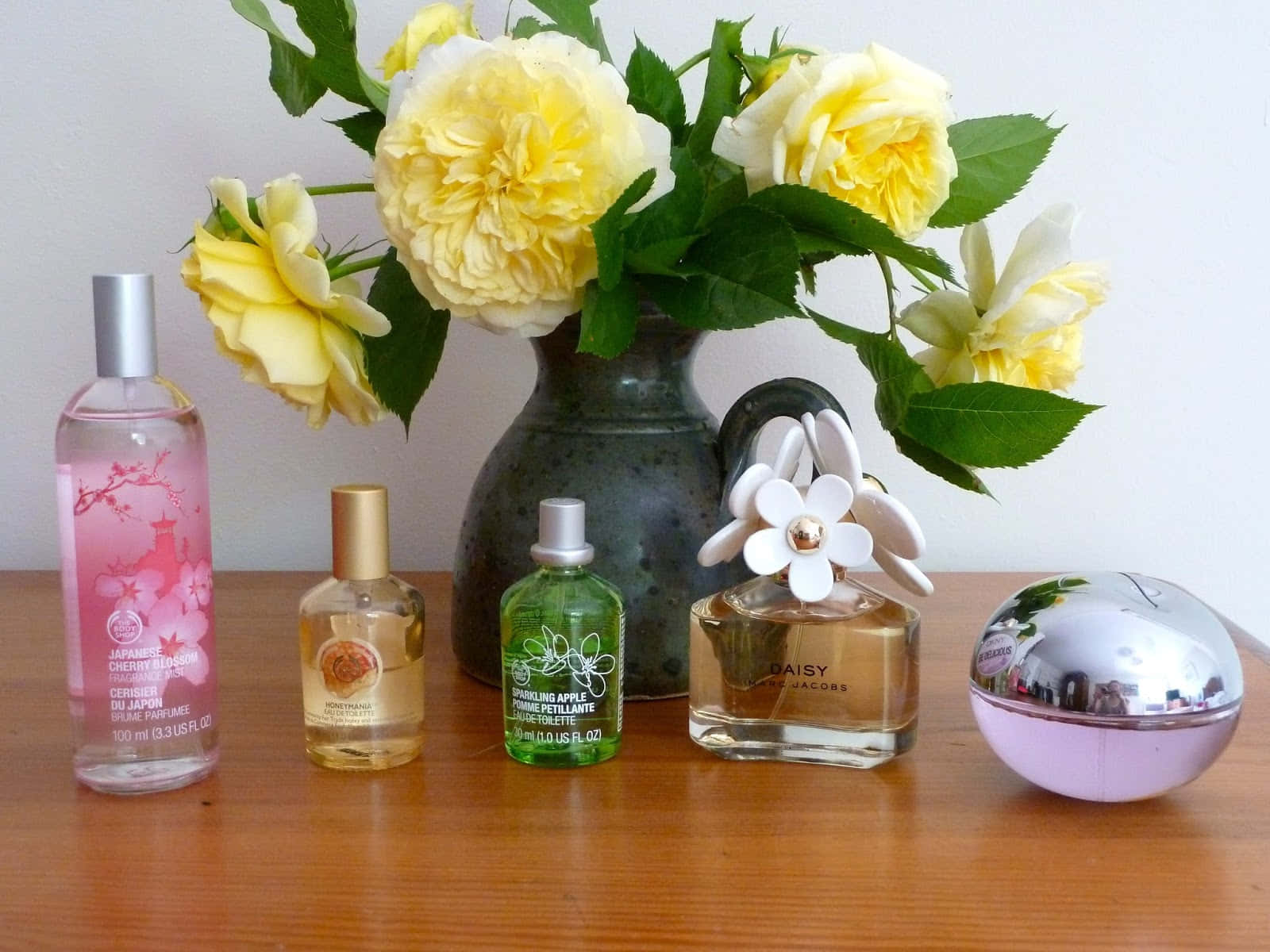 Hermosabotella De Perfume De Primavera Rodeada De Flores Coloridas. Fondo de pantalla