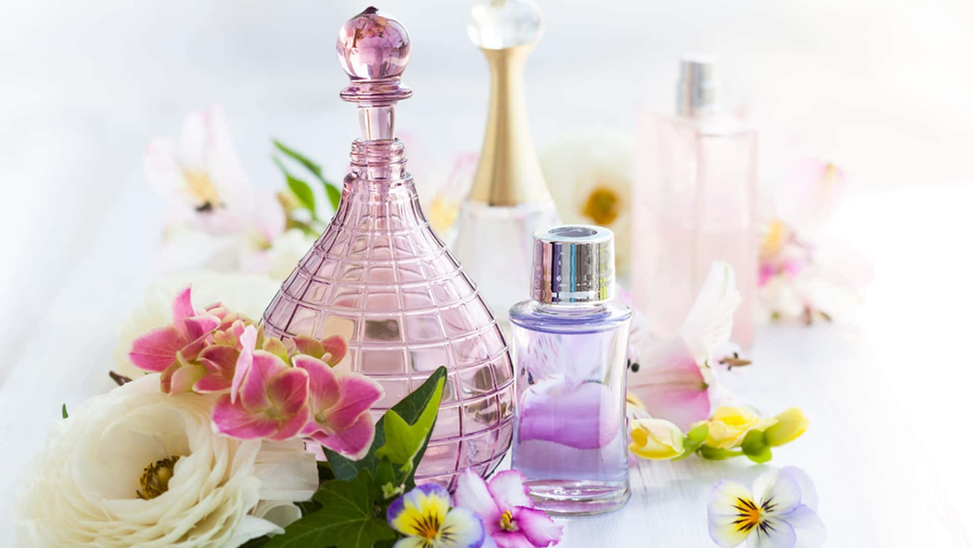 A Spring Perfume bottle surrounded by colorful flowers Wallpaper