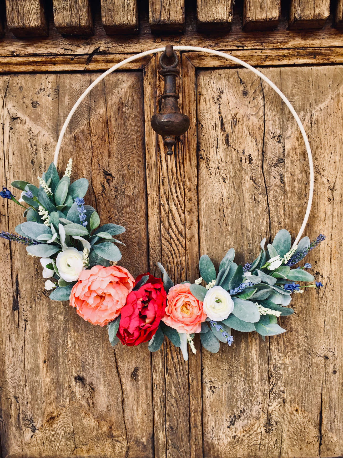 Caption: Vibrant Spring Wreath on a Rustic Door Wallpaper