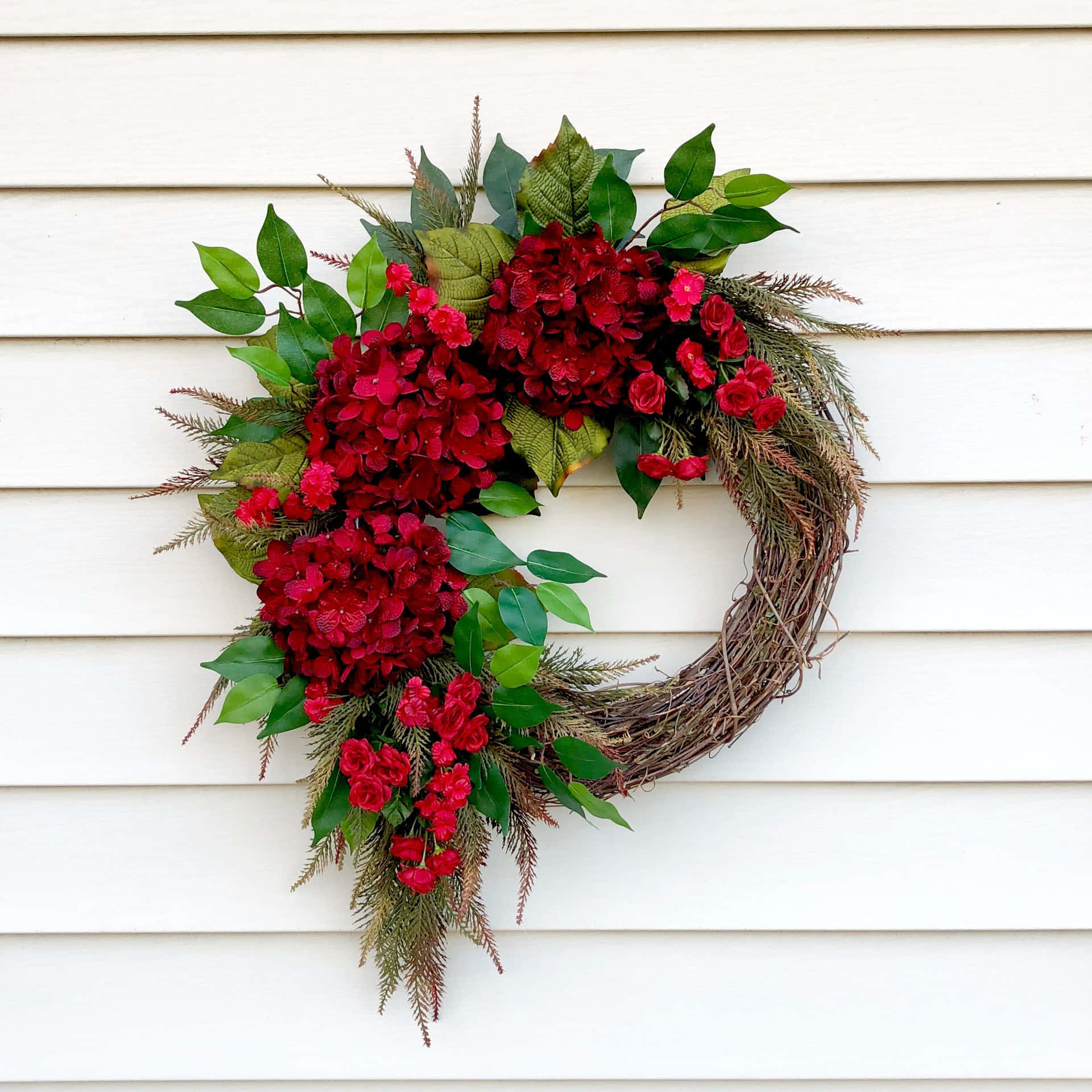Caption: Beautifully Crafted Spring Wreath on a Wooden Door Wallpaper