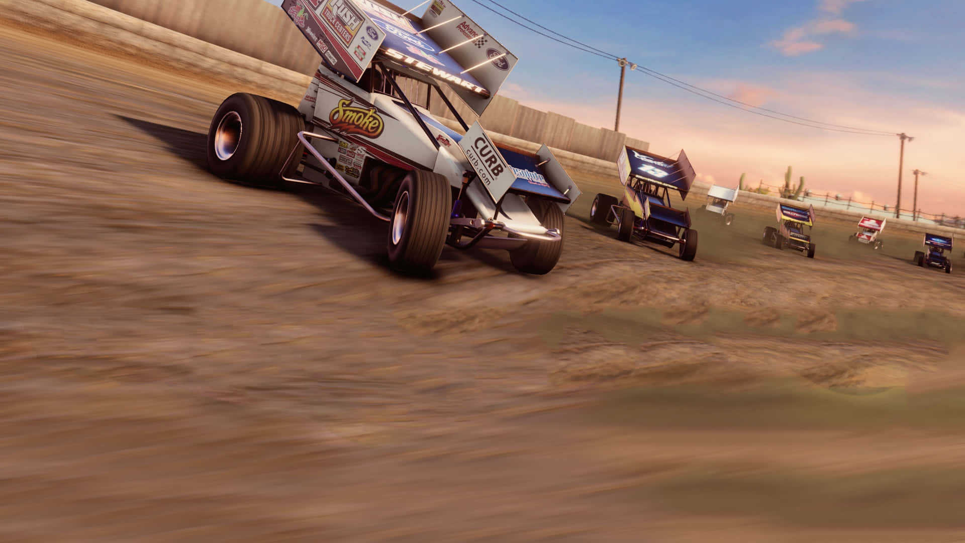 A Dirt Track With Several Cars Racing In The Background Wallpaper