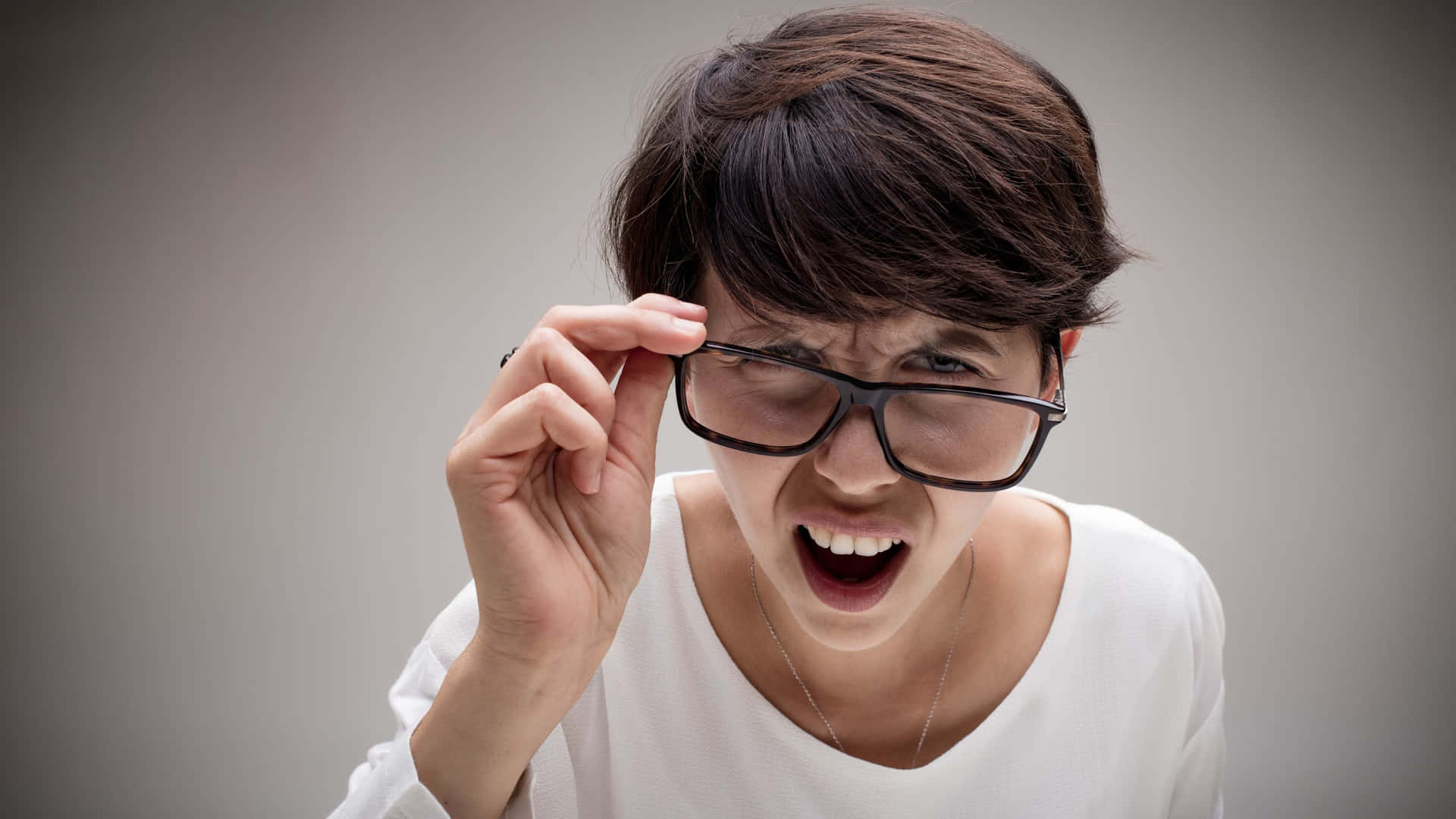 Squinting Person Holding Glasses Wallpaper
