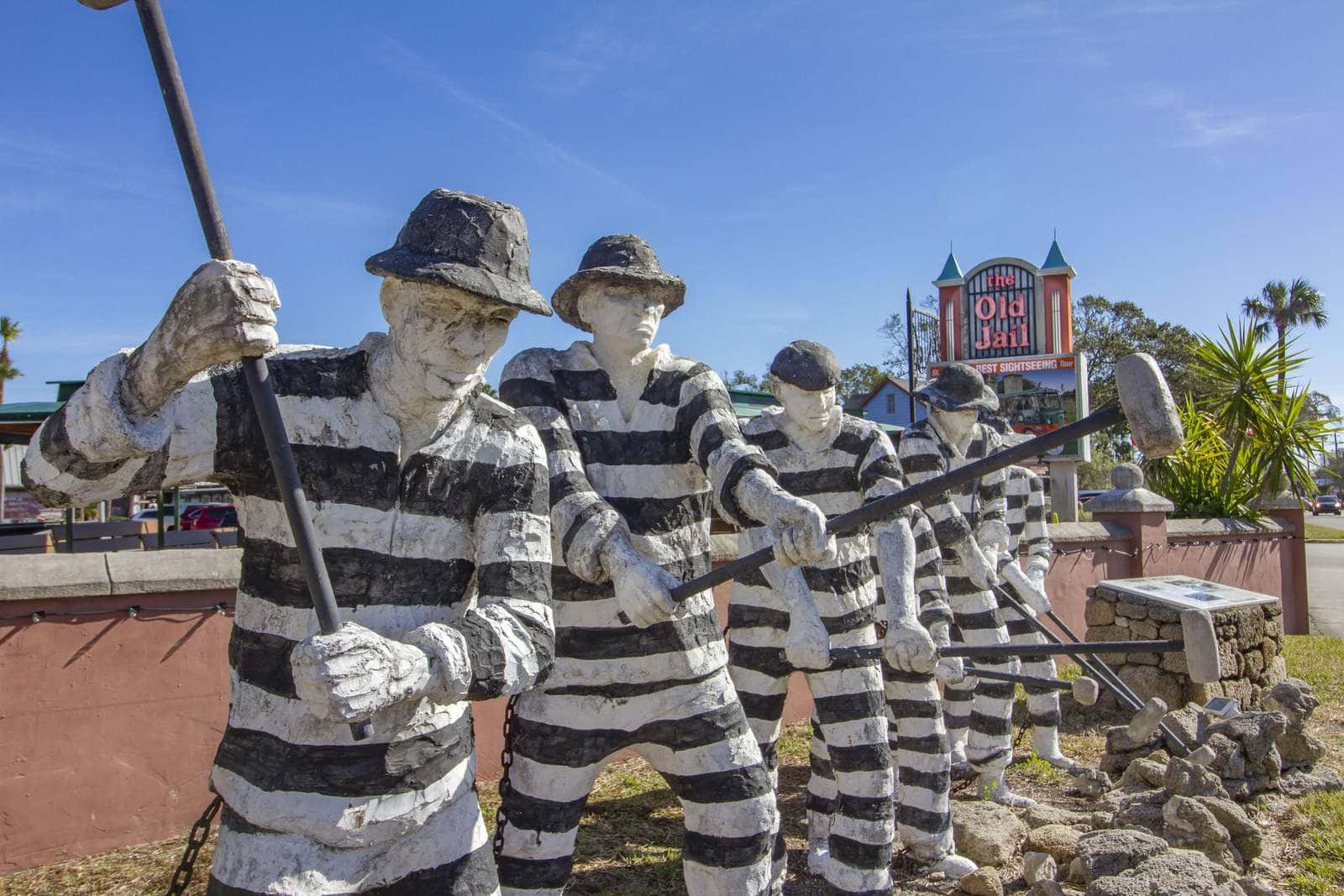 A Group Of Statues Of Prisoners Standing In Front Of A Building