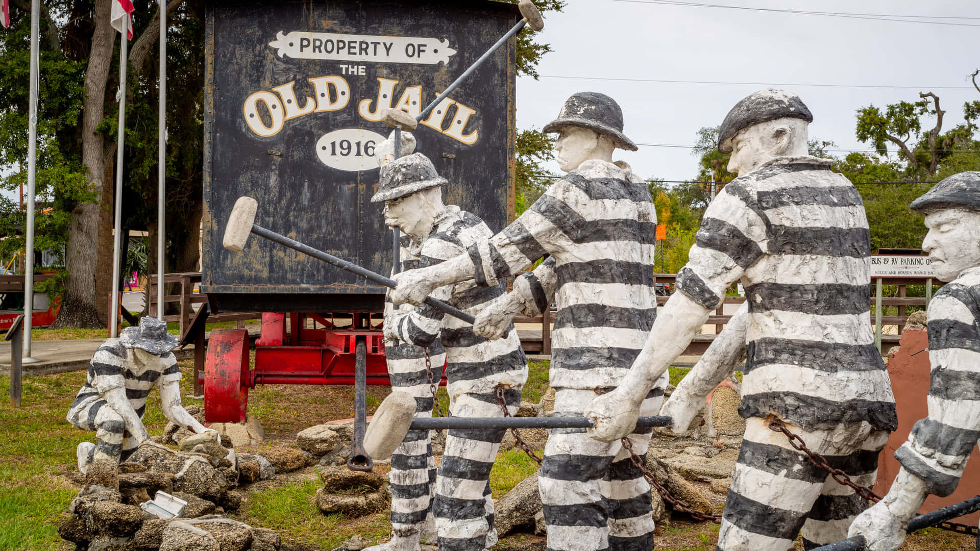 Old Jail Statues In Front Of A Sign