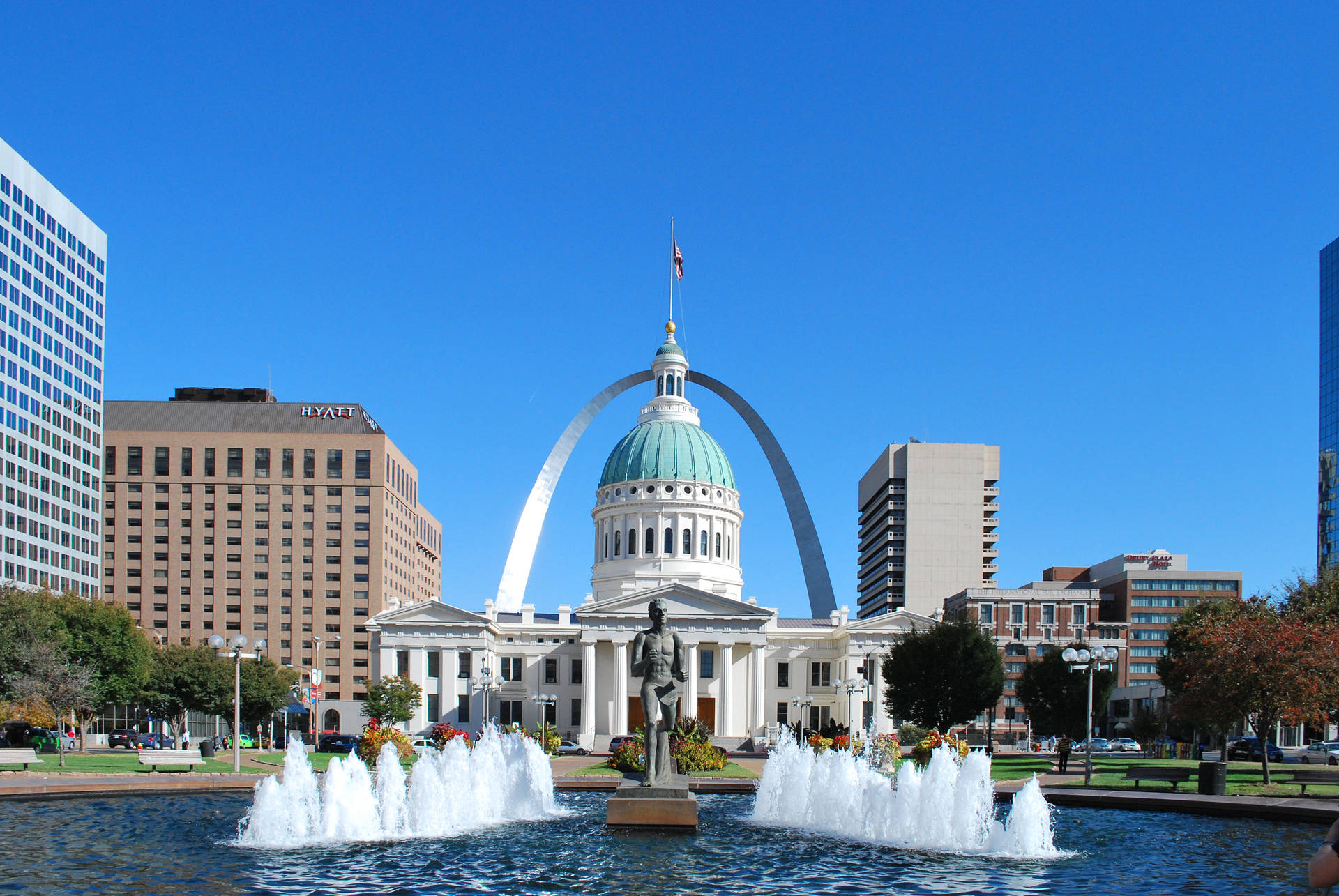 Mesmerizing View of the St. Louis Arch with a Glistening Fountain in Foreground Wallpaper