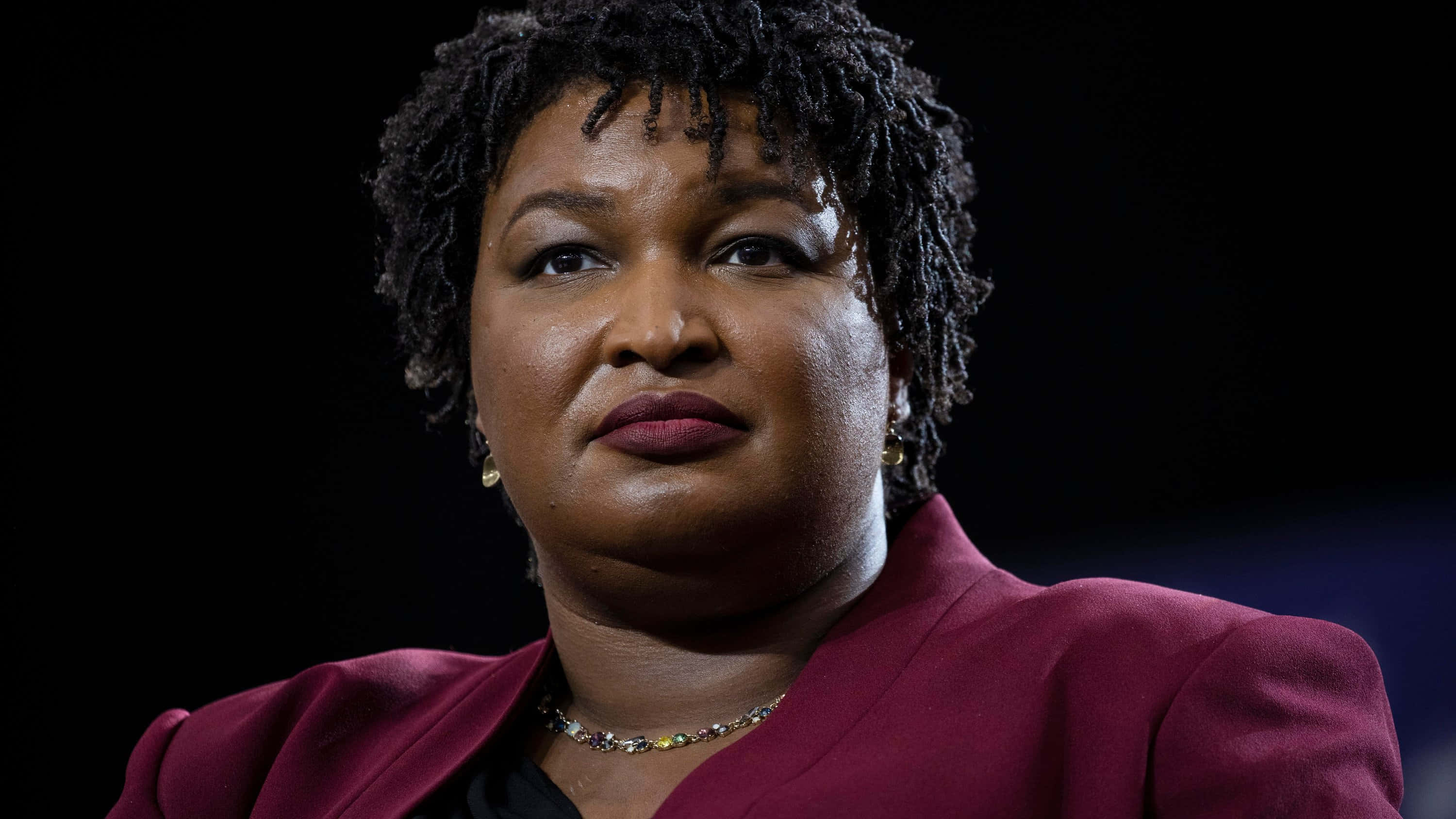Stacey Abrams Standing With Determined Look Wallpaper