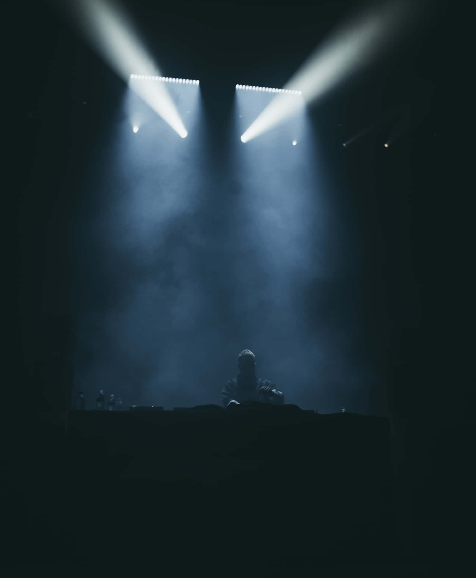 A Dj Is Playing In Front Of A Spotlight