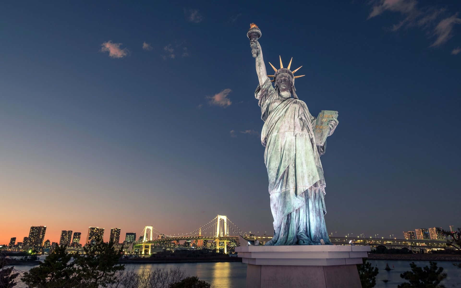 The Statue Of Liberty Is Lit Up At Dusk