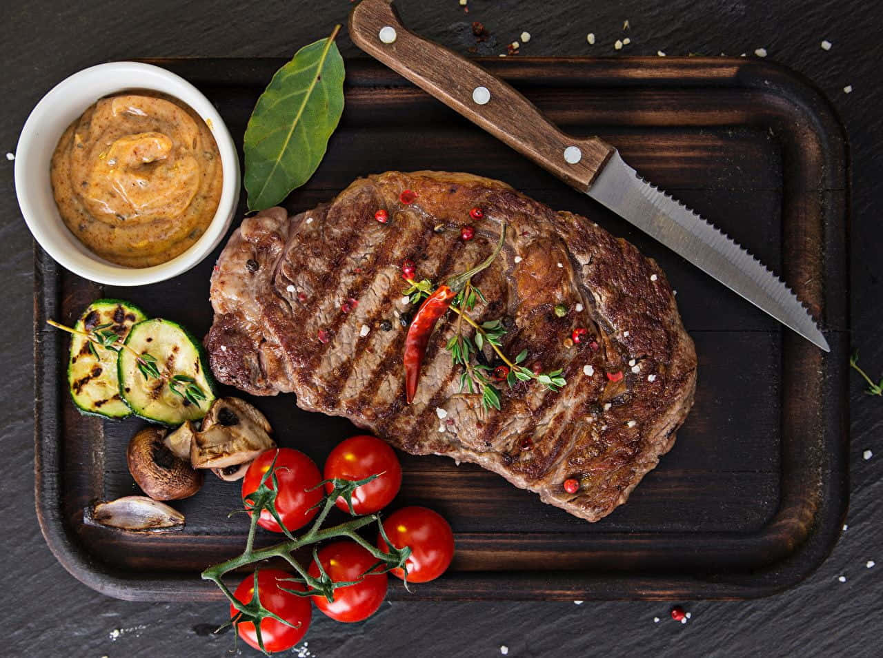 Steak On A Wooden Tray With Vegetables And Sauce