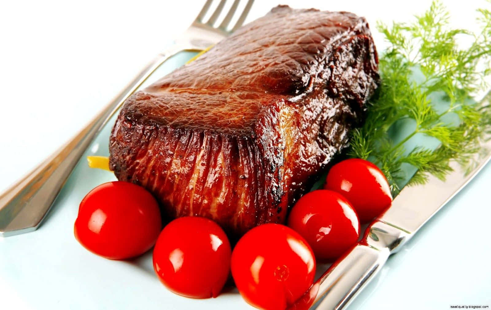 A Steak With Tomatoes And A Fork On A Plate