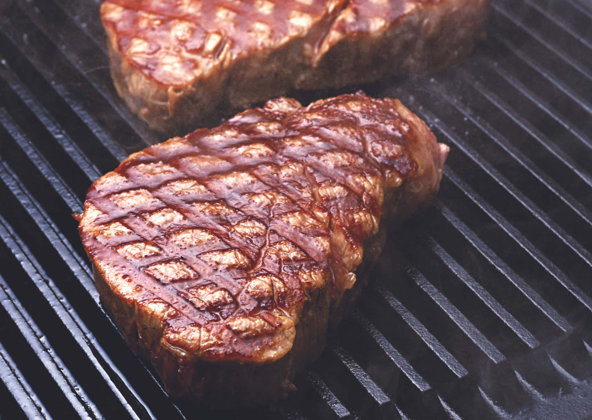 A Steak Is Being Cooked On A Grill