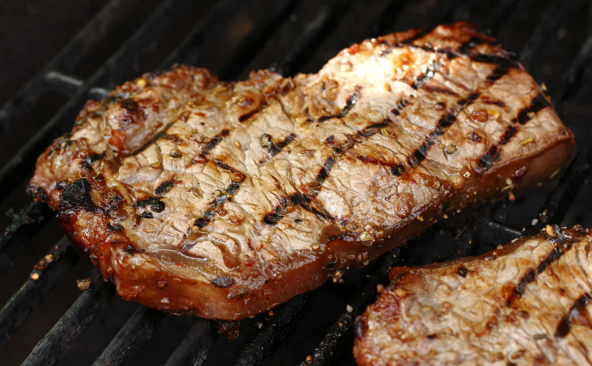 Two Pieces Of Steak On A Grill