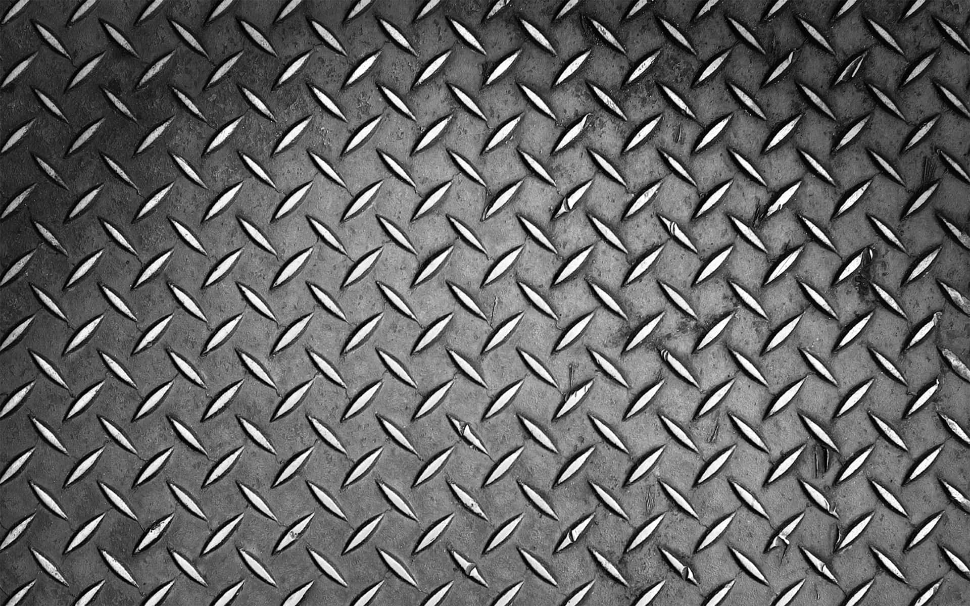 En sort og hvid foto af et metalplade. Wallpaper