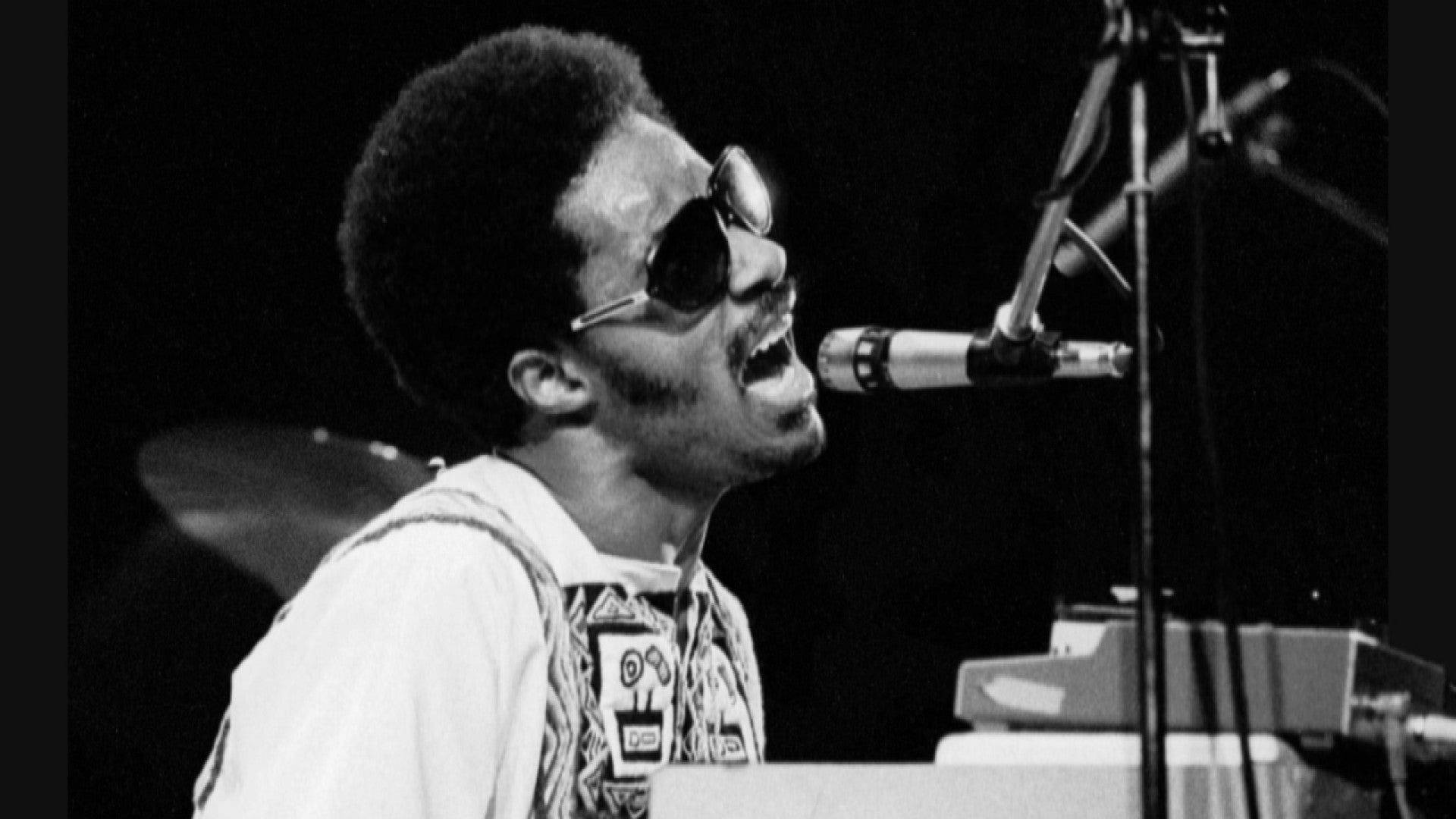 Stevie Wonder synger med passion pryder live tapet. Wallpaper