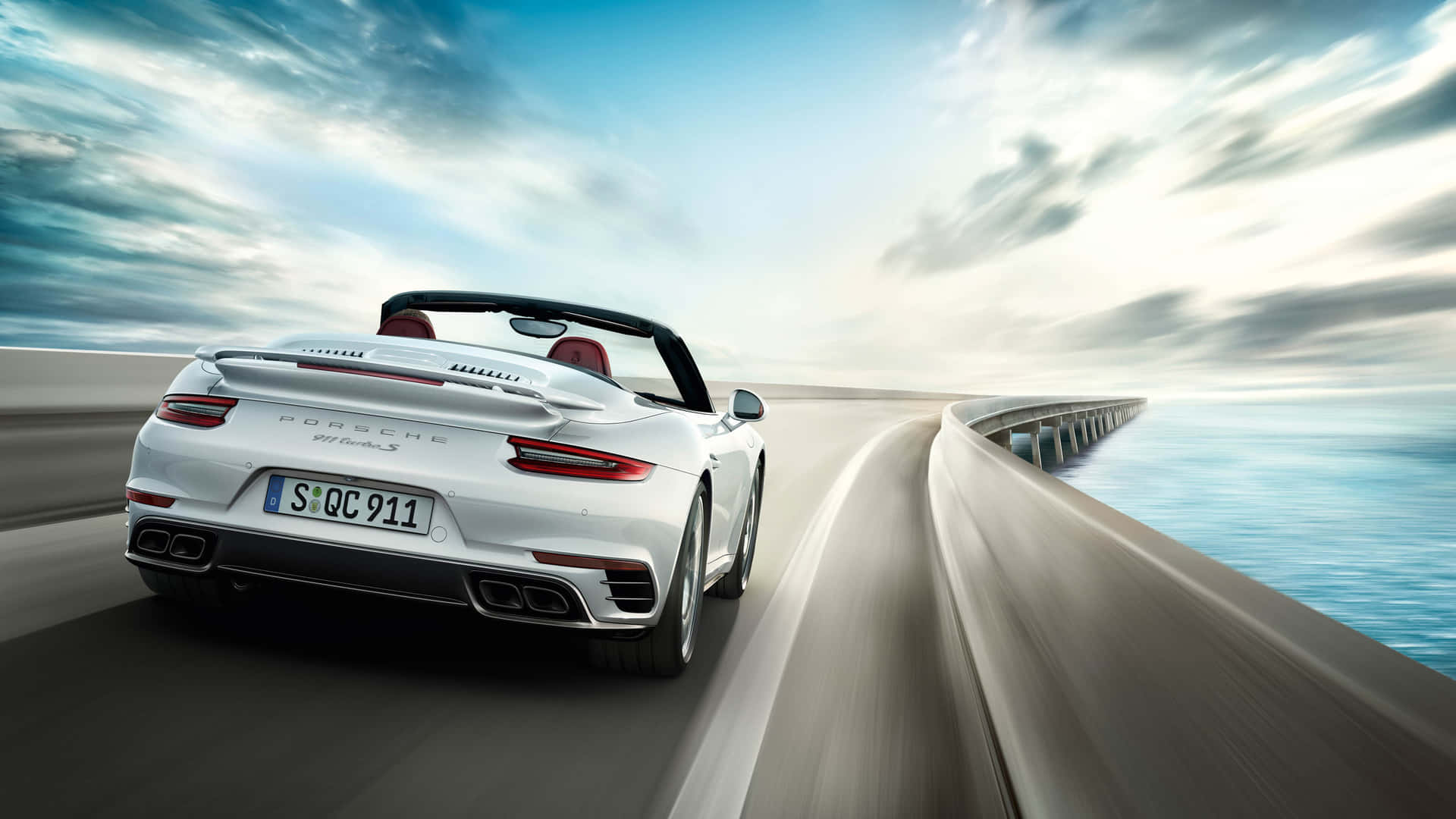Stilosaauto Sportiva Porsche Nera In Un Emozionante Road Trip Sotto Un Cielo Nuvoloso.