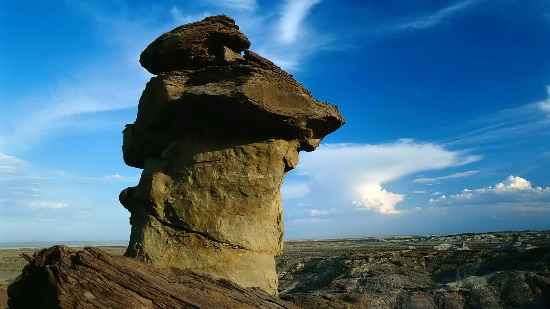 A Rock Formation In The Desert With A Blue Sky