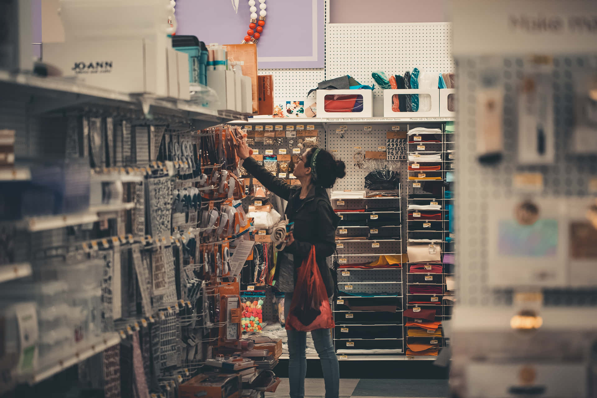 A Woman Is Looking At A Shelf Of Craft Supplies