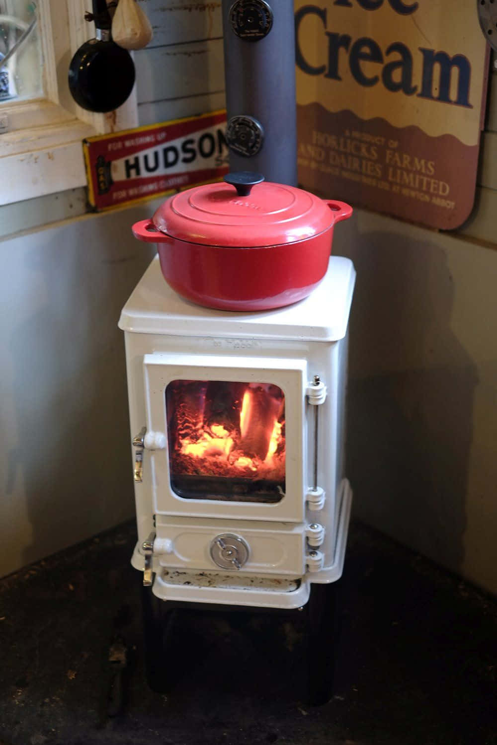 A Stove With A Red Pot On Top