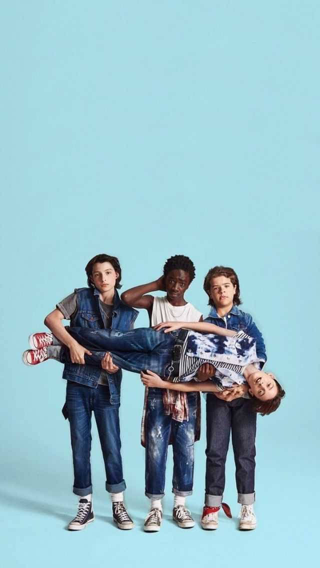 Einegruppe Von Jungen Steht Vor Einem Blauen Hintergrund. Wallpaper