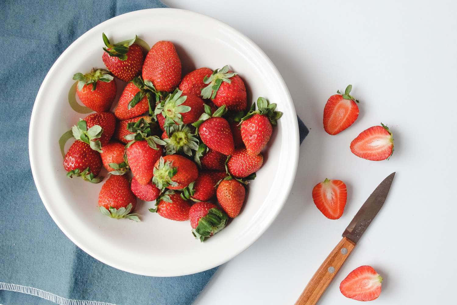 A White Bowl With Strawberries In It