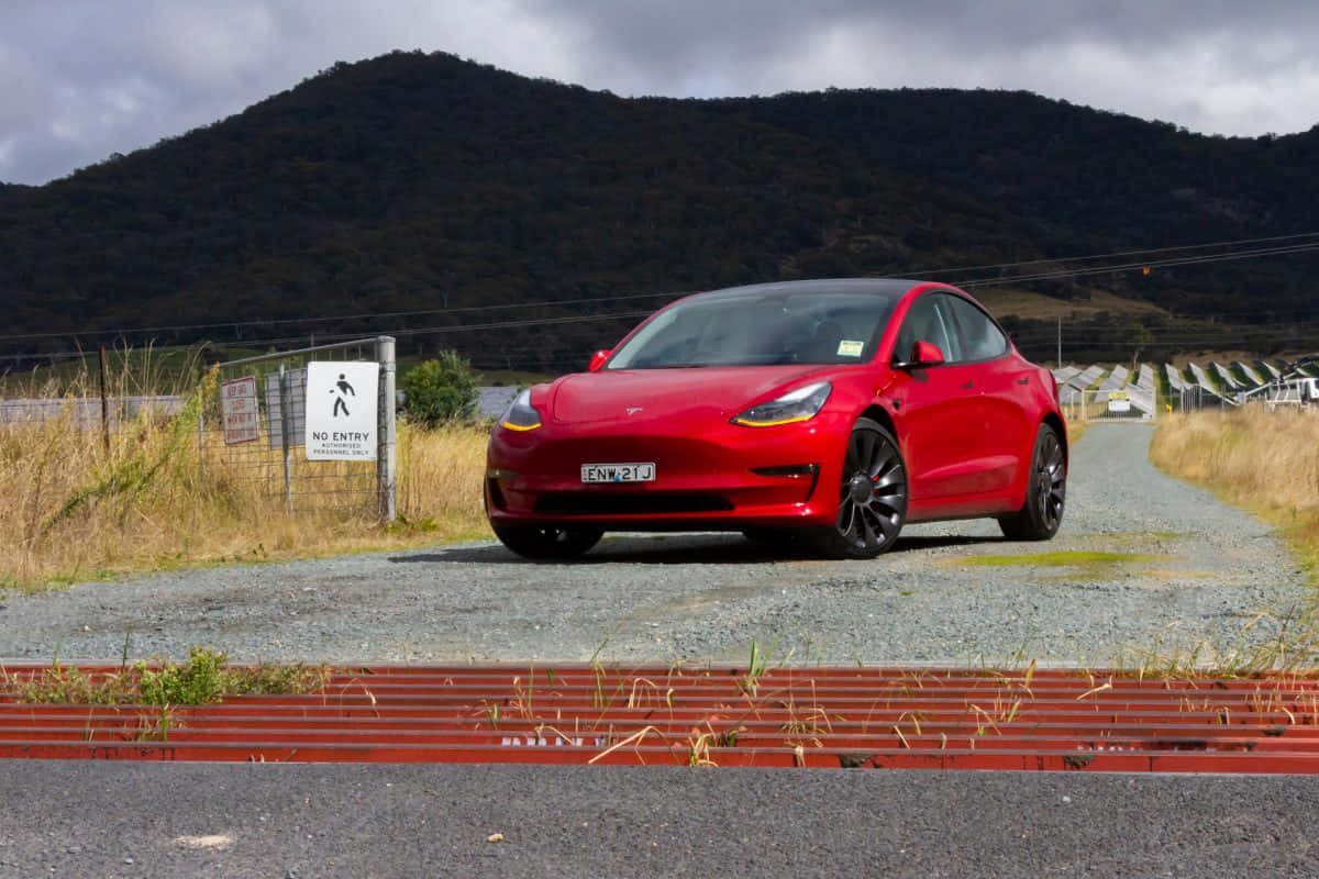 Striking White Tesla Model 3 On A Scenic Route Wallpaper