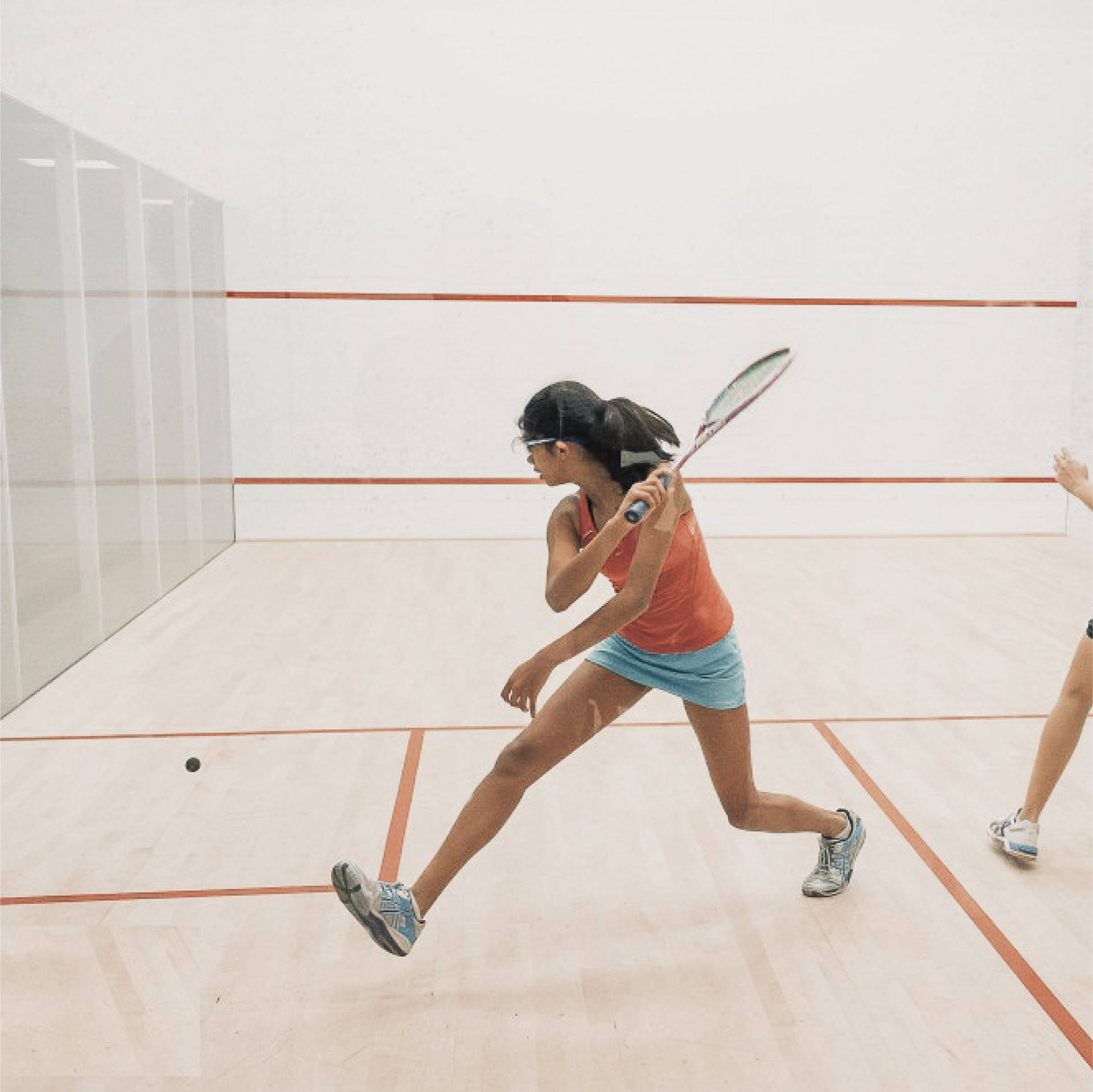 Strong Woman In Orange Playing Racquetball Wallpaper
