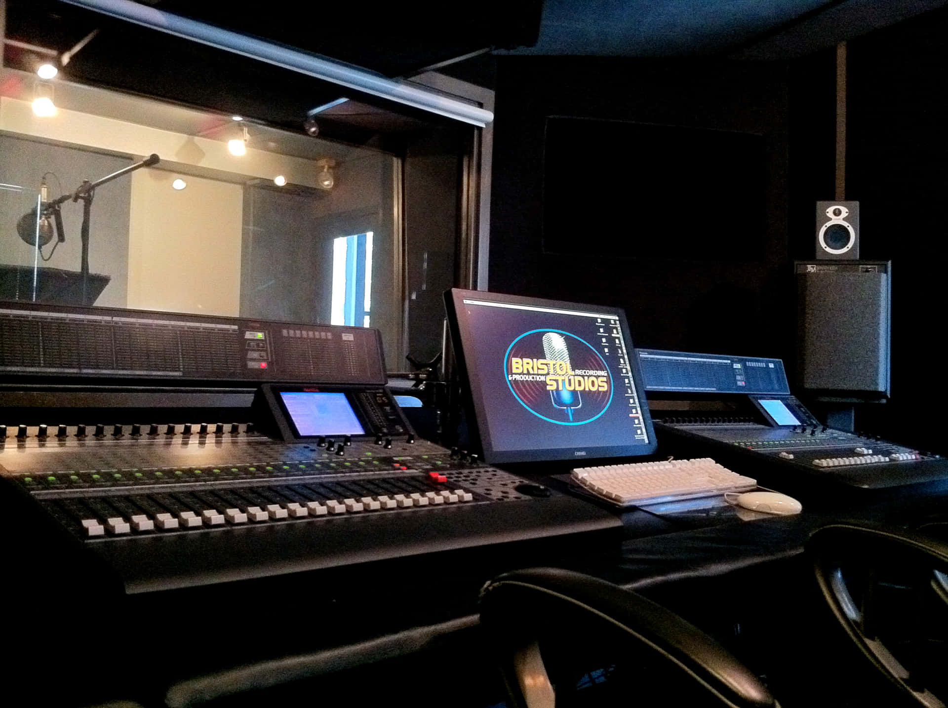 a recording studio with a monitor and keyboard