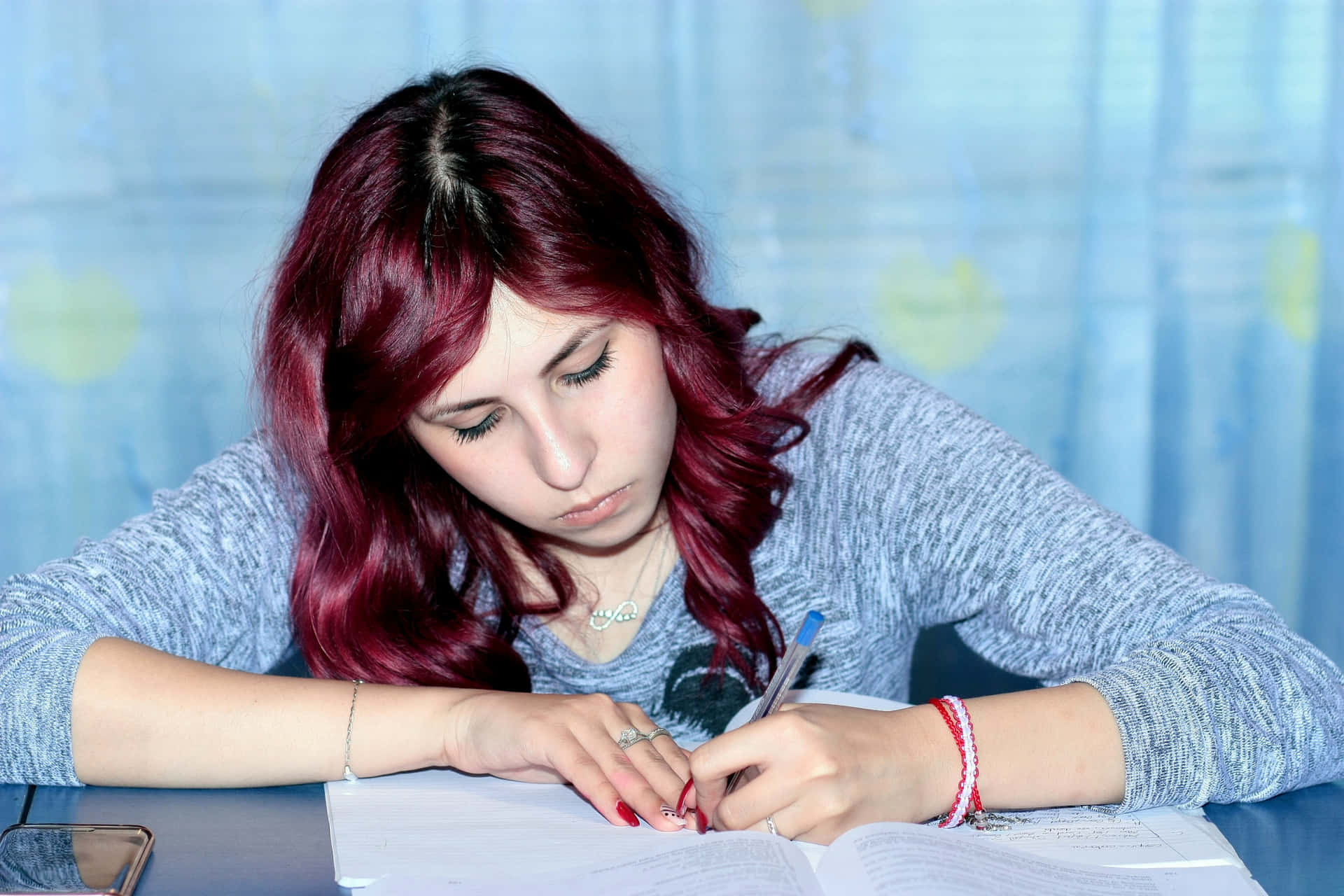A Girl Is Writing On A Piece Of Paper