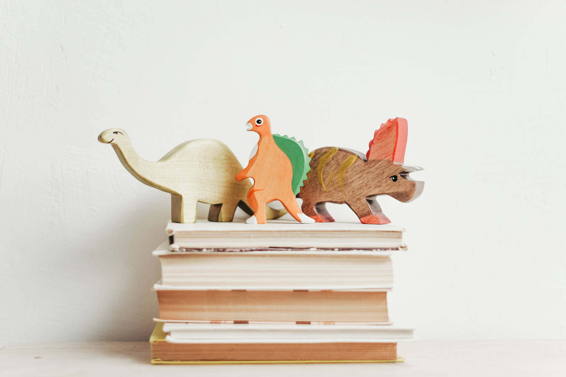Figurillasde Dinosaurios Para La Motivación De Estudio En Libros. Fondo de pantalla