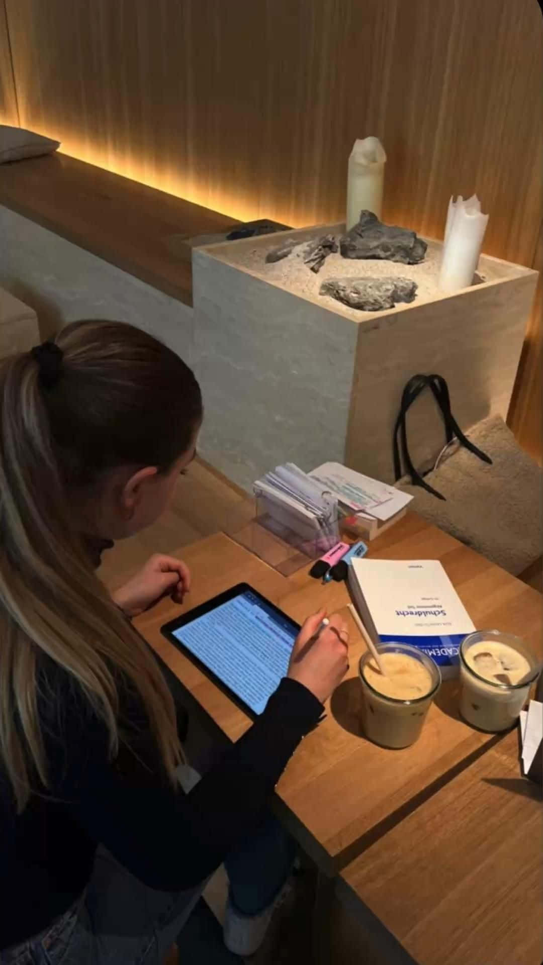 A Woman Is Using An Ipad At A Table