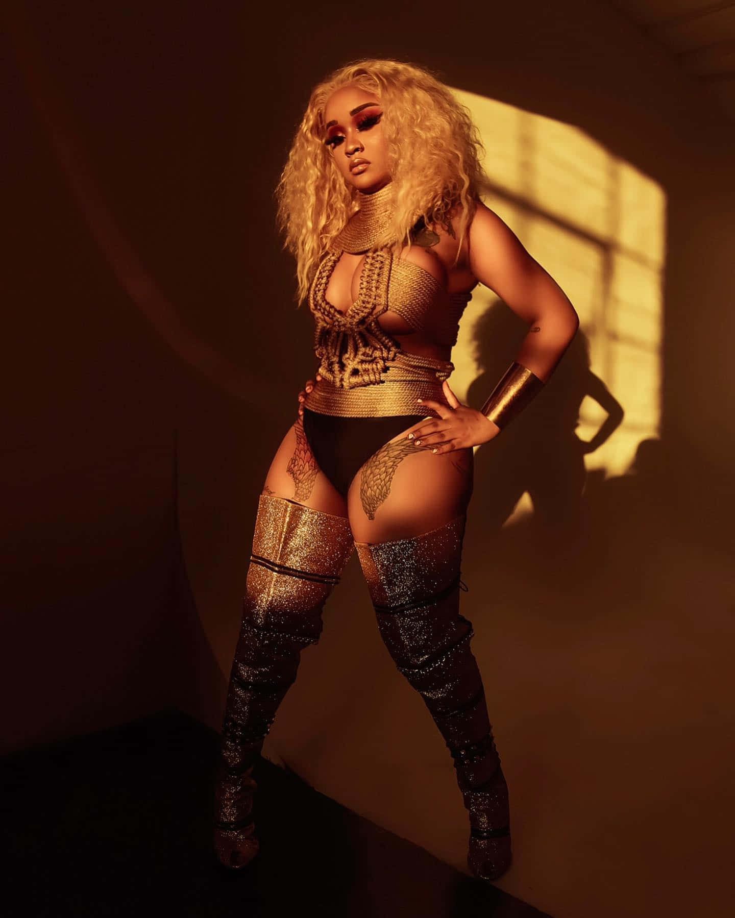 Stunna_ Girl_ Golden_ Outfit_ Shadow_ Play Wallpaper