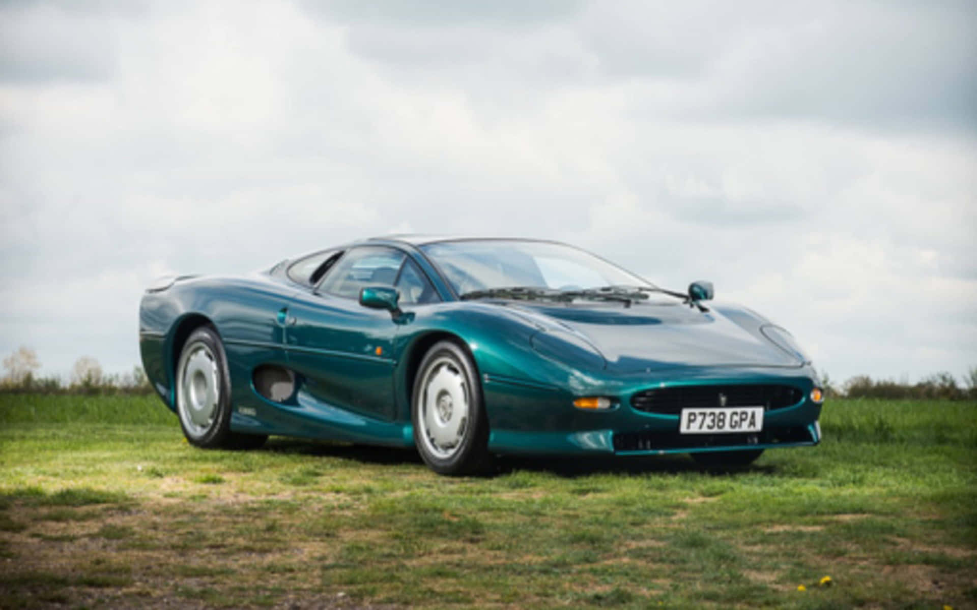 Download Stunning Jaguar Xj220 In Full Speed Wallpaper | Wallpapers.com