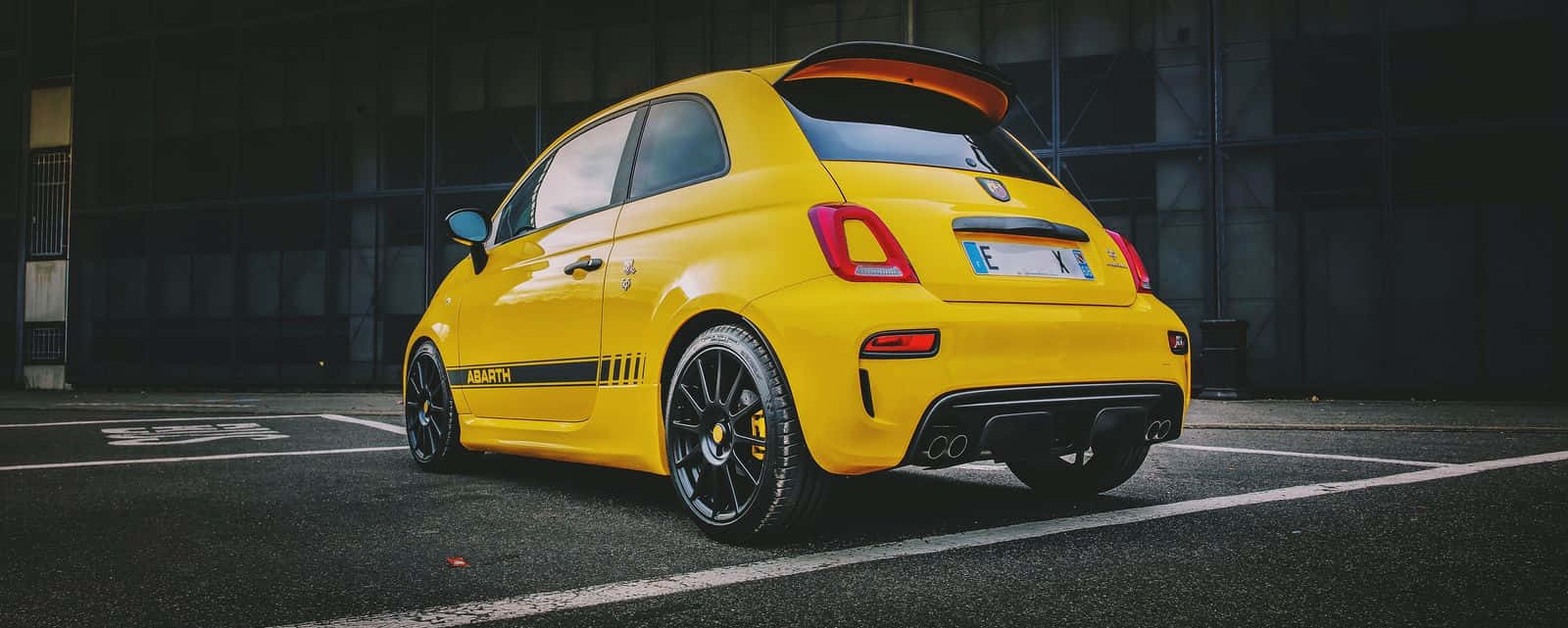 Stylish Abarth 595 In Night City Lights Wallpaper