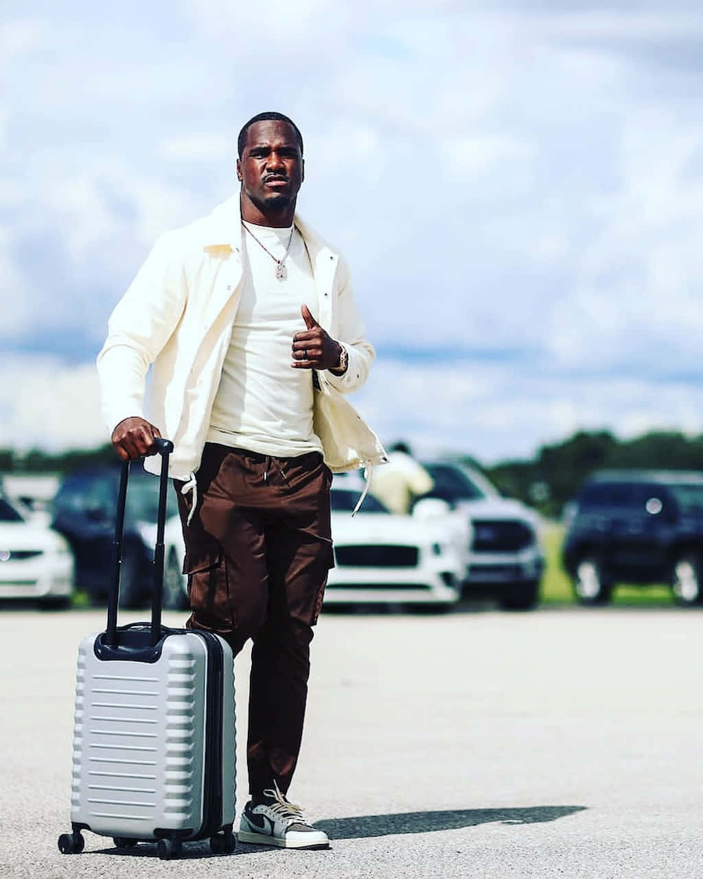 Download Stylish Athlete Traveling With Luggage Wallpaper | Wallpapers.com