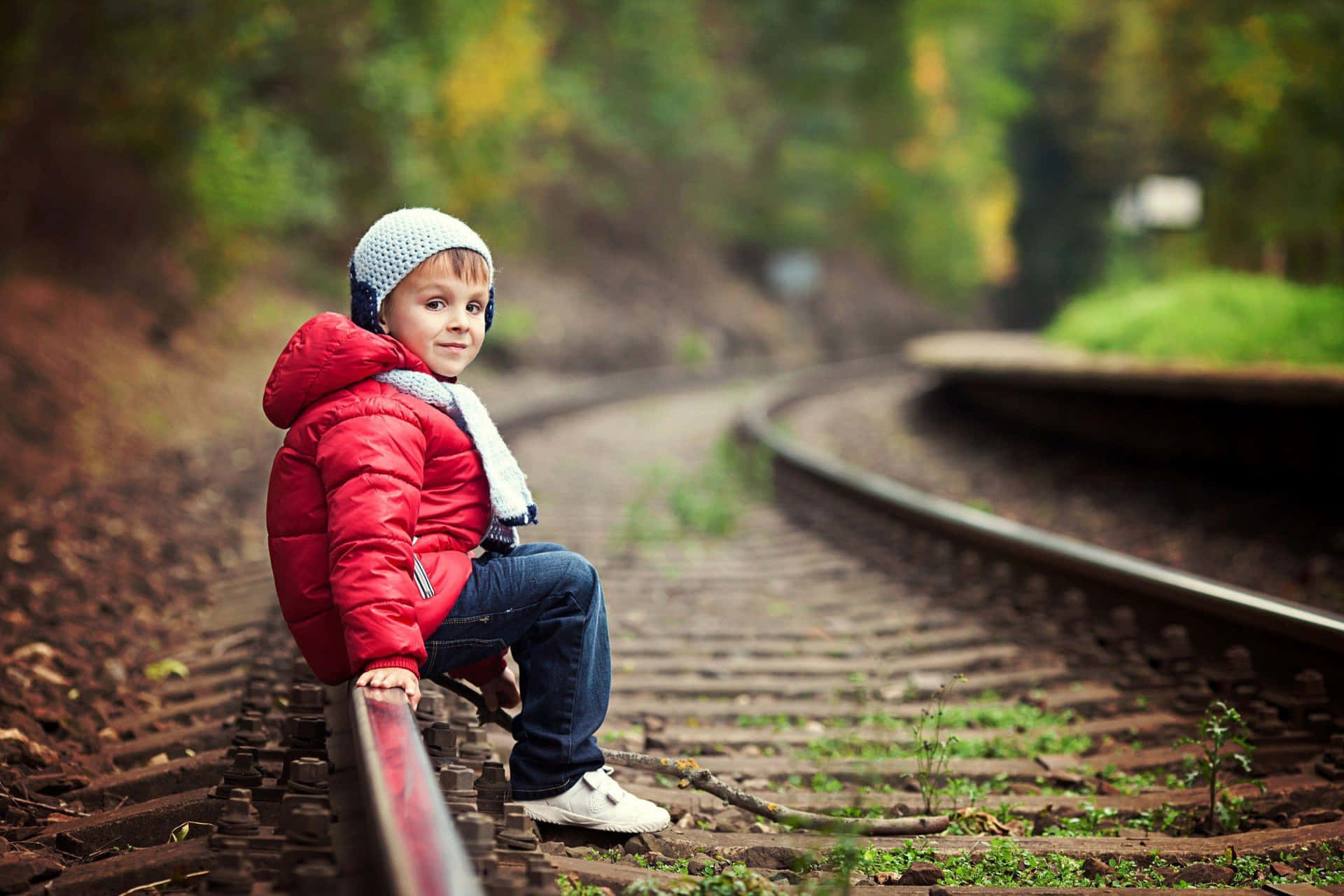 Stilfuld dreng siddende på jernbane Wallpaper