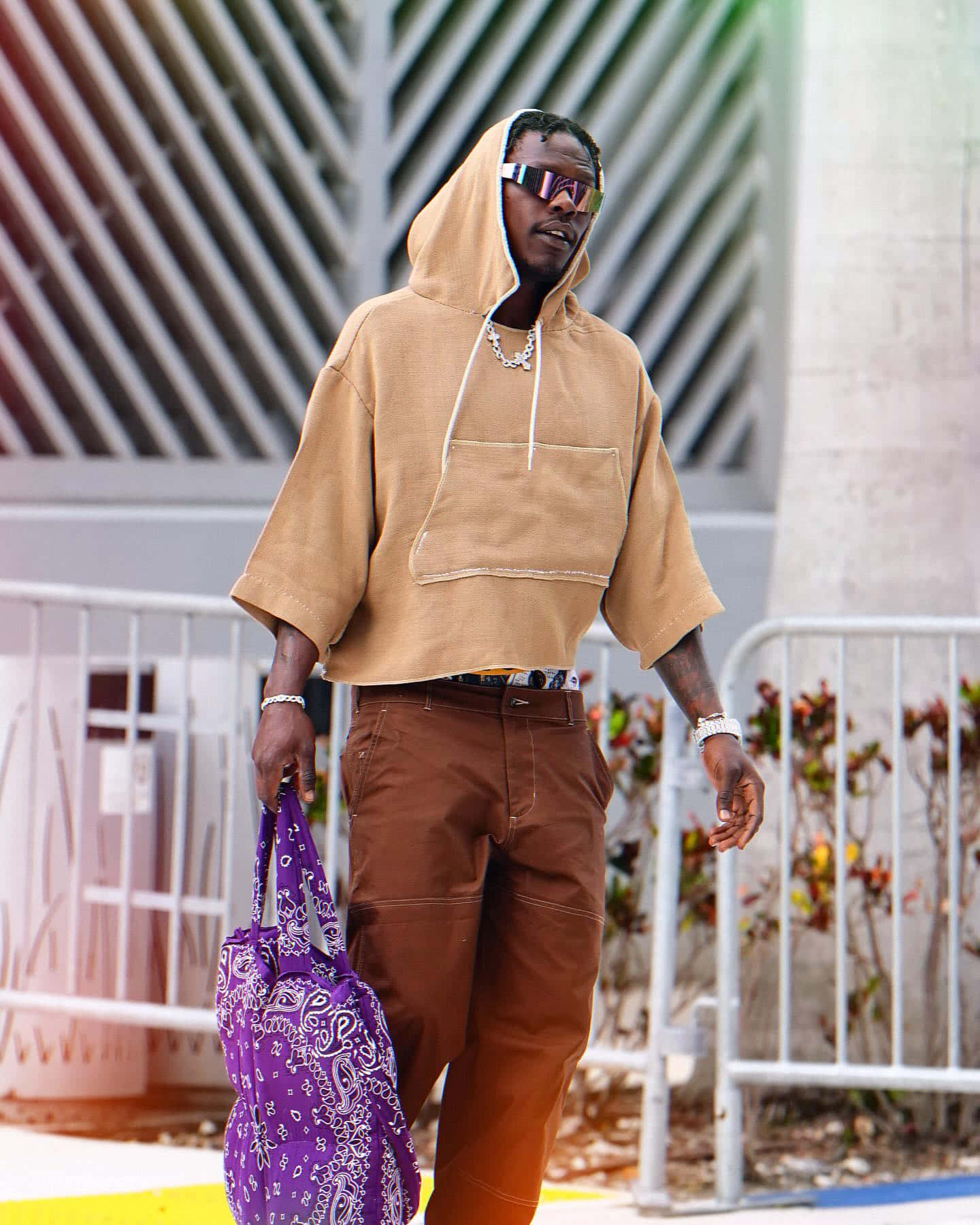 Stylish Man Walkingwith Purple Bag Wallpaper