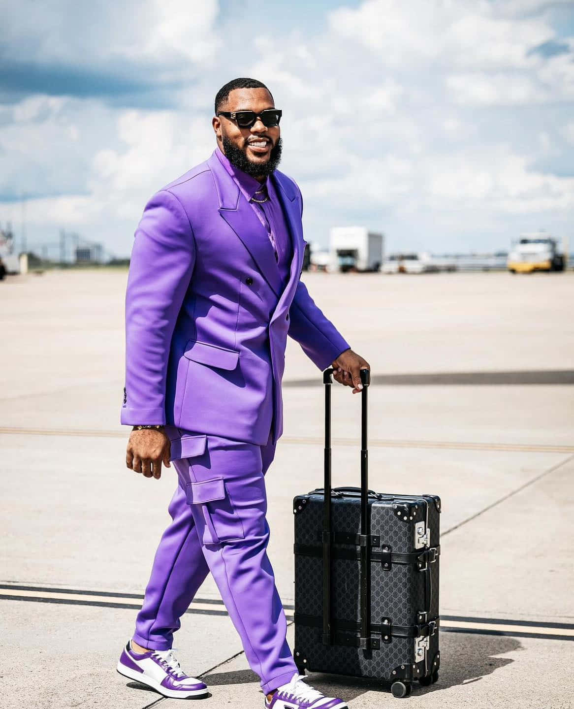 Stylish Manin Purple Suitwith Luggage Wallpaper