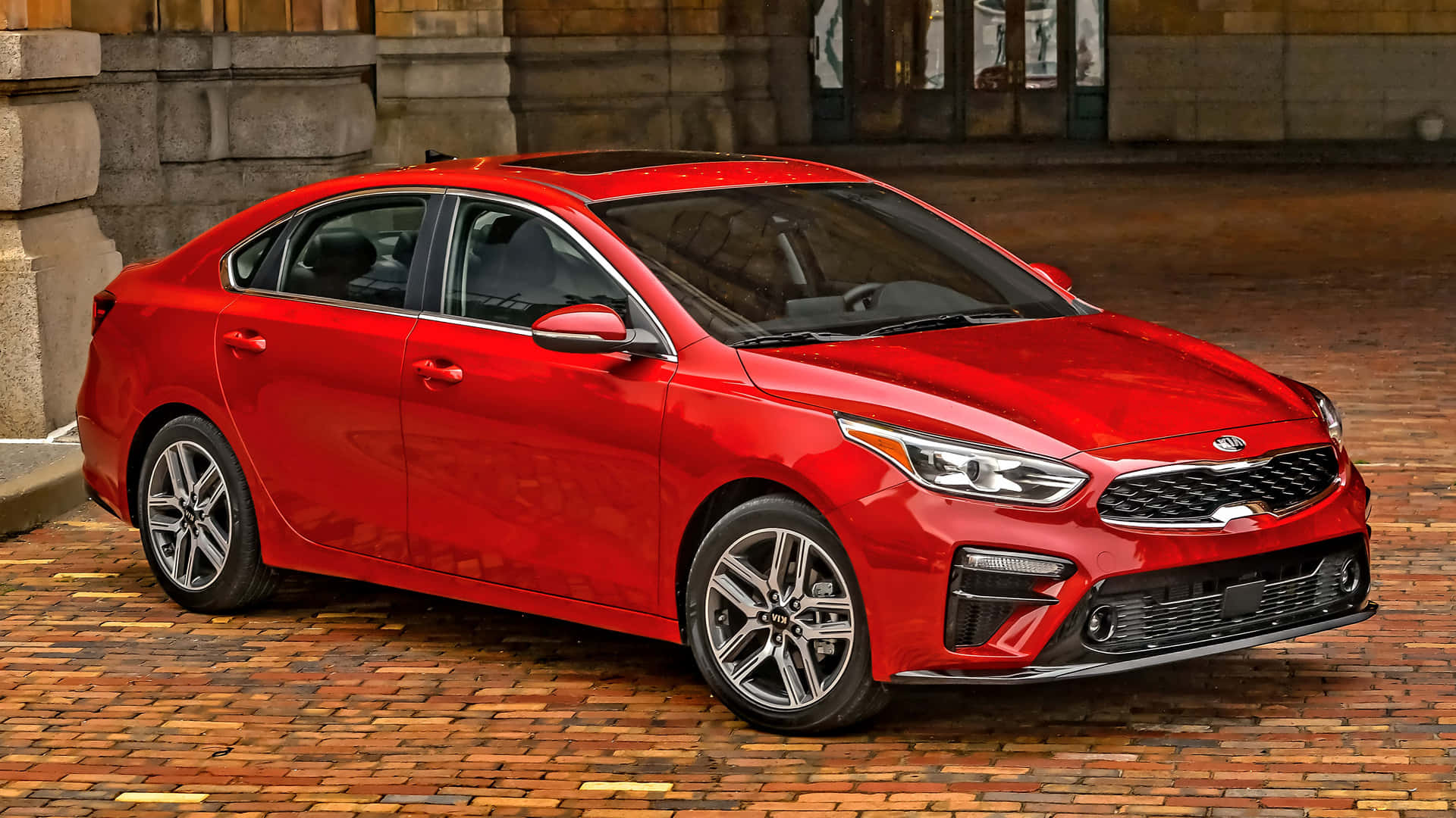Download Stylish Red Kia Forte On Road Wallpaper | Wallpapers.com